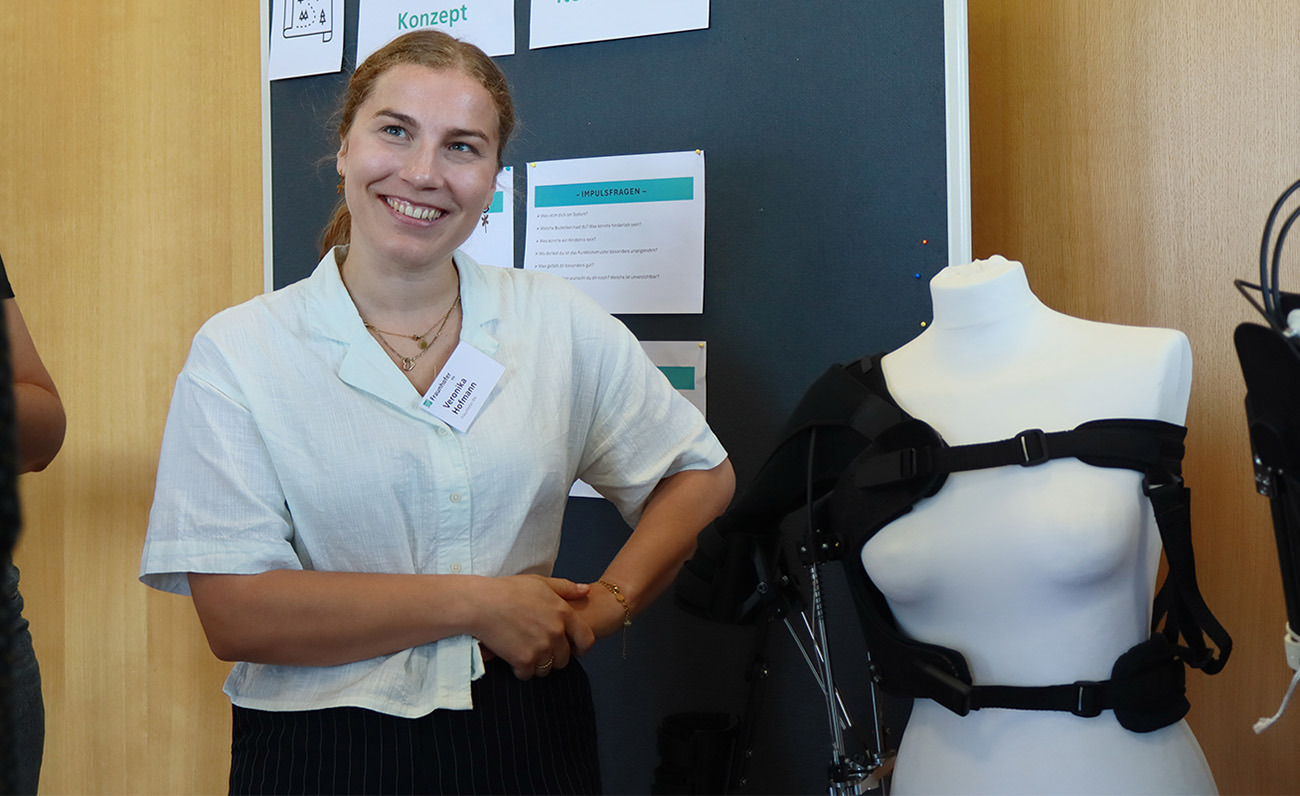 Veronika Hofmann, investigadora de Fraunhofer IPA, mostrando diferentes demostradores mec&aacute;nicos de exoesqueletos.